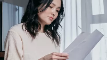 woman looking at a letter, resignation letter templates 2023