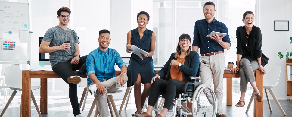 A group of coworkers smiling & a gradient blue background.
