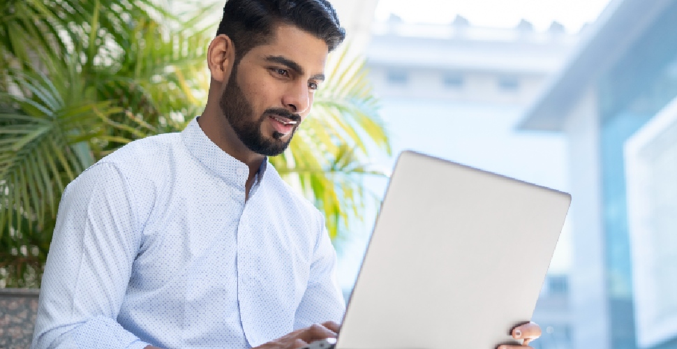 Indian male white-collar professional typing on his laptop