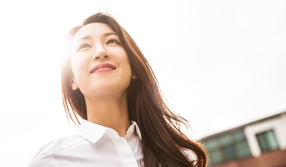 Female professional wearing a white shirt smiling and looking positive.