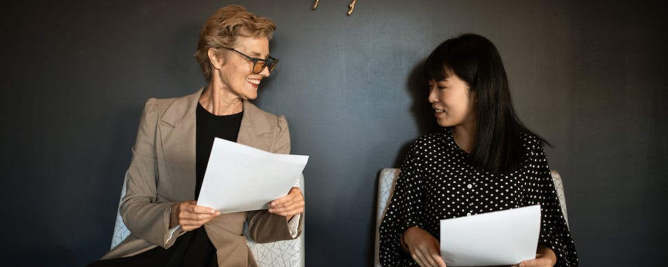 Women Sitting on Chairs Holding Documents. Photo by RDNE Stock project via Pexels