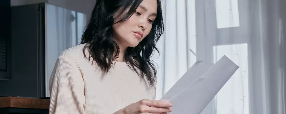 woman looking at a letter, resignation letter templates 2023