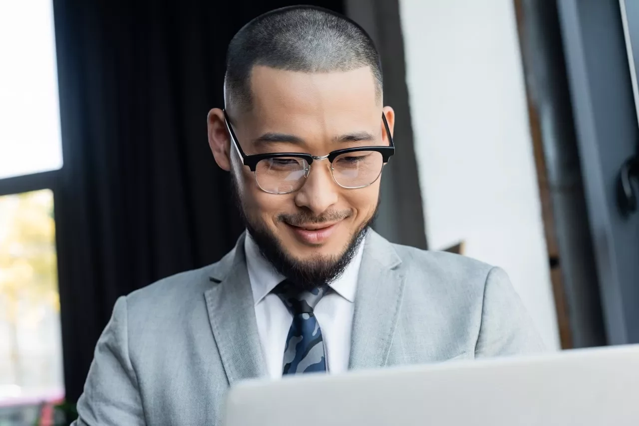 Executive smiling on his laptop